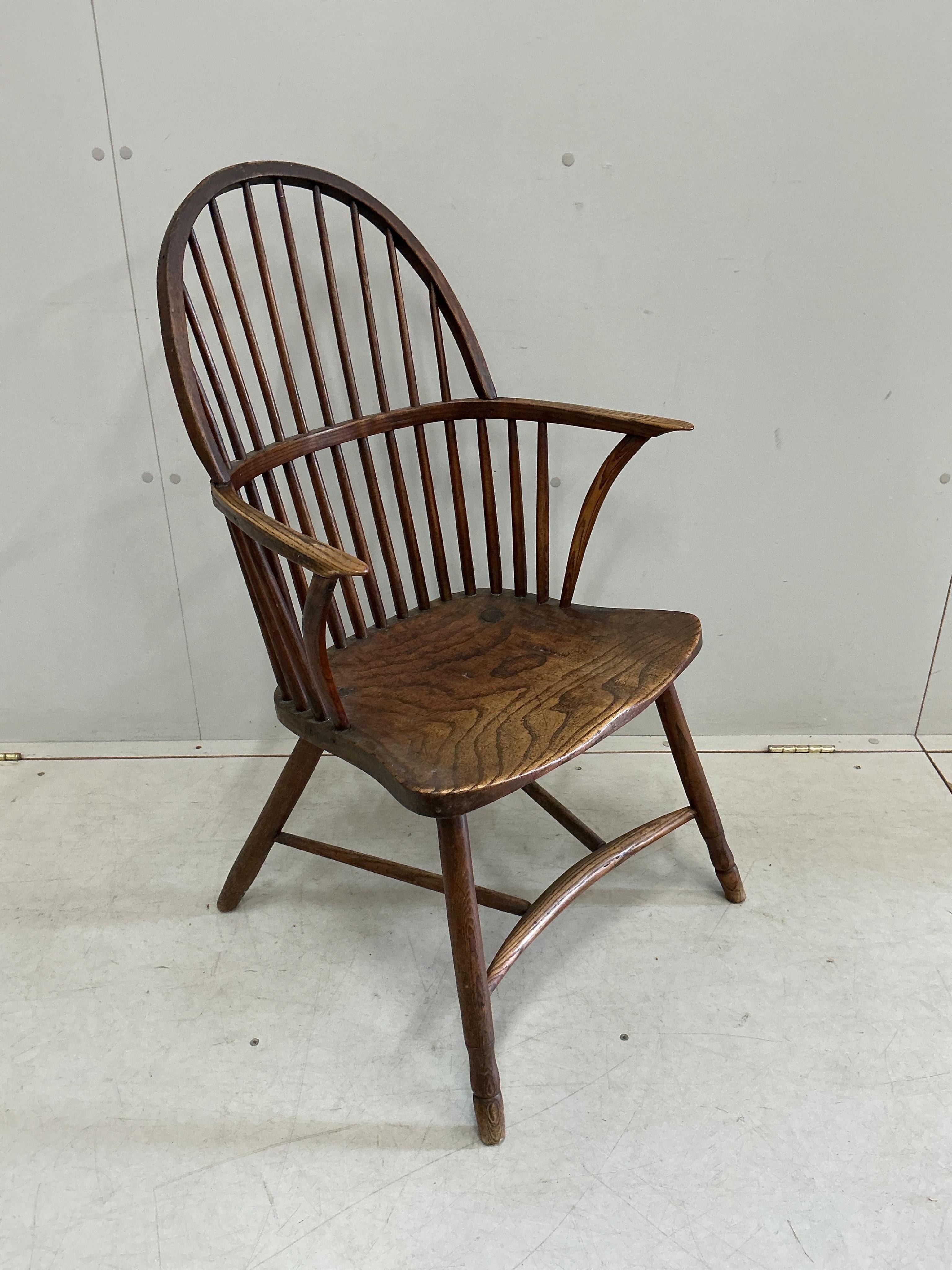 An early 19th century West Country ash and elm Windsor comb back elbow chair, width 57cm, depth 40cm, height 94cm